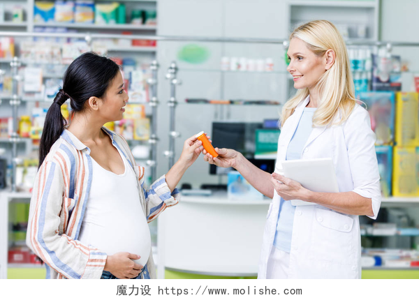 医生在为孕妇拿着叶酸药剂师给孕妇丸